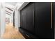 Hallway with built-in black cabinets, gold hardware, and hardwood floors at 6147 E Desert Cove Ave, Scottsdale, AZ 85254