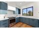 Contemporary kitchen with blue cabinets, stainless steel appliances, and elegant white countertops at 6147 E Desert Cove Ave, Scottsdale, AZ 85254