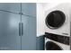 Laundry room features stackable washer/dryer and modern cabinetry at 6147 E Desert Cove Ave, Scottsdale, AZ 85254