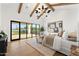 Bright main bedroom featuring wooden floors, modern furniture, and expansive doors opening to the backyard at 6147 E Desert Cove Ave, Scottsdale, AZ 85254