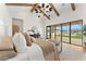 Bright bedroom featuring high ceilings, exposed beams, modern chandelier and floor-to-ceiling doors to the backyard at 6147 E Desert Cove Ave, Scottsdale, AZ 85254