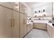 Walk-in pantry with custom shelves, farmhouse sink, and contrasting herringbone tile floor at 6147 E Desert Cove Ave, Scottsdale, AZ 85254
