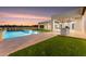Inviting pool and spa combo with travertine tile, water features, and a covered patio with an outdoor kitchen at 6147 E Desert Cove Ave, Scottsdale, AZ 85254