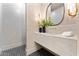 Sleek powder room featuring a marble countertop, modern fixtures, and stylish black and white tiled flooring at 6147 E Desert Cove Ave, Scottsdale, AZ 85254