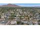 Wide aerial view of the neighborhood showcasing homes, mature trees, streets, and a mountain backdrop at 6207 E Rose Circle Dr, Scottsdale, AZ 85251