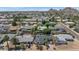 An aerial view showcases the neighborhood with mountain views in the distance on a sunny day at 6207 E Rose Circle Dr, Scottsdale, AZ 85251