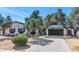 Charming single-story home with a manicured yard and a two-car garage under a clear blue sky at 6207 E Rose Circle Dr, Scottsdale, AZ 85251