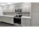 Modern kitchen with stainless steel appliances, gray cabinetry, white countertops, and stylish backsplash at 6207 E Rose Circle Dr, Scottsdale, AZ 85251