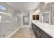 Open bathroom with a glass shower and a double vanity with dark wood cabinets and white countertop at 6503 E Bluefield Ave, Phoenix, AZ 85054