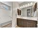 Traditional bathroom with dual sinks, dark cabinets, wood tile flooring and a tub/shower combo at 6503 E Bluefield Ave, Phoenix, AZ 85054