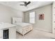 Simple bedroom with a white bed, a desk, and a ceiling fan with neutral-colored carpet at 6503 E Bluefield Ave, Phoenix, AZ 85054