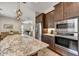 Modern kitchen with stainless steel appliances and open layout to the dining and living area at 6503 E Bluefield Ave, Phoenix, AZ 85054