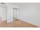 Open bedroom with wood-look flooring and a mirrored closet, adding space and light at 6863 W Sunnyside Dr, Peoria, AZ 85345