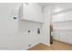 Bright laundry room features a water heater and built-in white cabinetry for plenty of storage space at 6863 W Sunnyside Dr, Peoria, AZ 85345