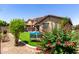 Backyard with lush synthetic grass, inviting seating, landscaping, and privacy fence at 7015 W Melody Dr, Laveen, AZ 85339
