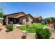 A well-maintained backyard with artificial turf, desert landscaping and covered patio at 7015 W Melody Dr, Laveen, AZ 85339