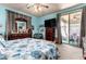 A spacious bedroom with bright blue walls, a floral bed set, and a sliding glass door to a covered patio at 7015 W Melody Dr, Laveen, AZ 85339