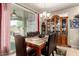 A dining room with a marble table, cushioned chairs, a china cabinet and an outdoor view through a sliding door at 7015 W Melody Dr, Laveen, AZ 85339