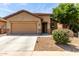Charming single-Gathering home featuring a two-car garage, desert landscaping, and a covered entryway at 7015 W Melody Dr, Laveen, AZ 85339