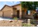 Charming single-Gathering home featuring a two-car garage, desert landscaping, and a covered entryway at 7015 W Melody Dr, Laveen, AZ 85339
