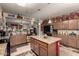 Well-lit kitchen with granite countertops, pendant lighting, tile flooring and a center island with bar seating at 7015 W Melody Dr, Laveen, AZ 85339