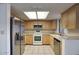 Modern kitchen with stainless steel appliances, light wood cabinets, and tiled countertops at 722 W Topeka Dr, Phoenix, AZ 85027