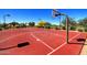 Outdoor basketball court area with bright red surface, white line markings, and desert landscaping at 8433 E Leonora St, Mesa, AZ 85207