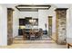 A dining area with stone columns, modern light fixture, and dark cabinetry provides an elegant setting for meals at 8433 E Leonora St, Mesa, AZ 85207