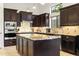Modern kitchen with a granite island, dark cabinets, and stainless steel appliances at 8433 E Leonora St, Mesa, AZ 85207