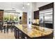 Elegant kitchen with large granite island and stainless steel appliances, open to the dining area at 8433 E Leonora St, Mesa, AZ 85207