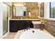Luxurious main bathroom with a soaking tub, stone accents, and bright lighting at 8433 E Leonora St, Mesa, AZ 85207