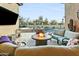 Inviting outdoor patio with a fire pit, lounge seating, and a pool in the background at 8433 E Leonora St, Mesa, AZ 85207