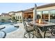 Backyard with a refreshing pool, spa, and seating around a warm fire pit, perfect for outdoor relaxation at 8433 E Leonora St, Mesa, AZ 85207