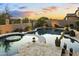Backyard oasis with a sparkling pool, spa, and lush desert landscaping for ultimate relaxation and privacy at 8433 E Leonora St, Mesa, AZ 85207