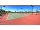 Well-maintained tennis courts with green playing surface, black netting, and picturesque mountain views in the background at 8433 E Leonora St, Mesa, AZ 85207