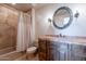 Bathroom featuring a shower-tub combo and vanity with stone countertops and wooden cabinets at 8606 E Arroyo Seco Rd, Scottsdale, AZ 85266