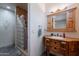 Charming bathroom showcasing a custom wood vanity, glass block shower, and tiled flooring at 8606 E Arroyo Seco Rd, Scottsdale, AZ 85266