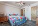 This cozy bedroom offers a large bed, ceiling fan, and natural light from the nearby windows at 8606 E Arroyo Seco Rd, Scottsdale, AZ 85266