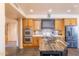 Updated kitchen with stainless steel appliances, tile backsplash, and an island for food prep at 8606 E Arroyo Seco Rd, Scottsdale, AZ 85266
