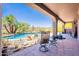 Relaxing pool area features desert landscaping, wrought iron fence, and covered patio with seating at 8606 E Arroyo Seco Rd, Scottsdale, AZ 85266