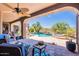 Beautiful covered patio overlooks a pool and spa surrounded by lush desert landscaping at 8606 E Arroyo Seco Rd, Scottsdale, AZ 85266