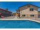Backyard view of pool and home, showcasing fenced yard with patio steps leading to the house's back entrance at 8829 W Sheridan St, Phoenix, AZ 85037