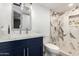 Upgraded bathroom with blue vanity, white marble countertop, and walk-in shower with glass doors and marble design at 8829 W Sheridan St, Phoenix, AZ 85037