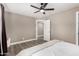 Bedroom with a ceiling fan, closet access, neutral paint, and wood-look floors at 8829 W Sheridan St, Phoenix, AZ 85037