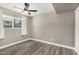 Bedroom featuring a ceiling fan, neutral paint, wood-look floors, and a big window at 8829 W Sheridan St, Phoenix, AZ 85037