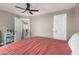 A cozy bedroom with a ceiling fan, light gray walls, a bed with a pink cover, and natural light at 8829 W Sheridan St, Phoenix, AZ 85037
