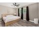 Cozy bedroom with a ceiling fan, neutral walls, and a big window that brings in natural light at 8829 W Sheridan St, Phoenix, AZ 85037