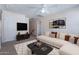 Bright living room featuring a modern sofa, ceiling fan, and stylish decor at 950 E Kelsi Ave, San Tan Valley, AZ 85140
