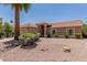 Tan single-story home featuring a tile roof, neutral desert landscaping, and mature palm tree in the front yard at 950 N Sailors Way, Gilbert, AZ 85234