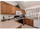 Functional kitchen featuring laminate countertops, white appliances, and wood cabinets at 950 N Sailors Way, Gilbert, AZ 85234